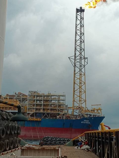 FPSO Mystras hull and flare tower seen from a support vessel