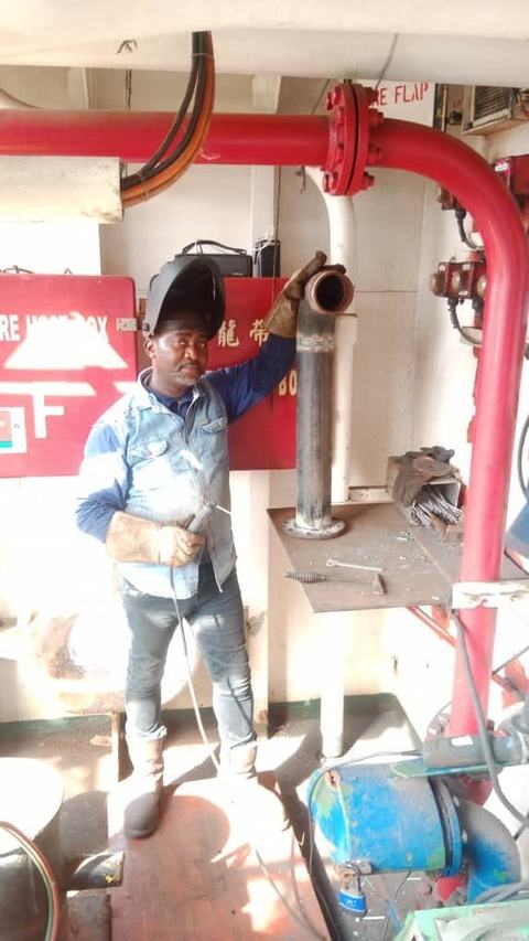 Welder at work on fire-suppression pipework